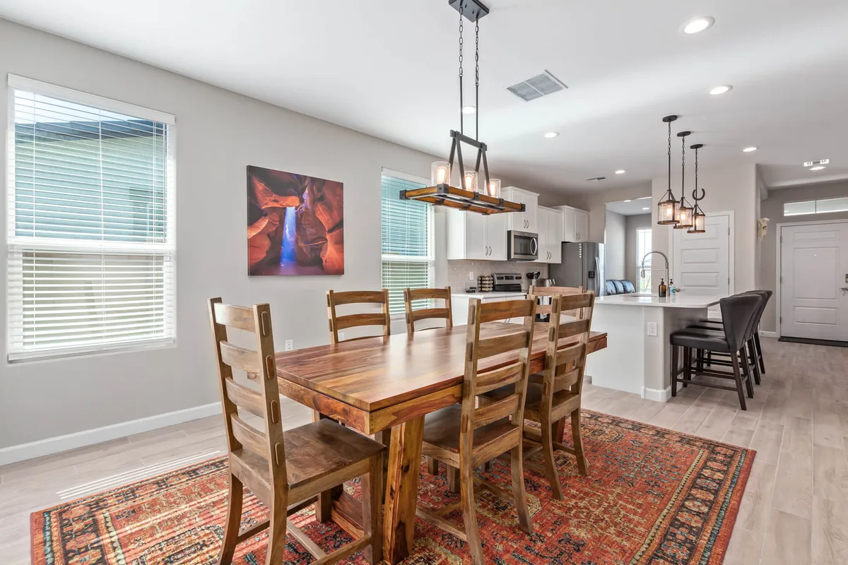 A cozy dining area is depicted here, with a dining table set beneath warm lighting fixtures and accented by southwestern-style artwork on the wall. The space is intimate yet welcoming, ideal for family meals, entertaining guests, and daily gatherings.